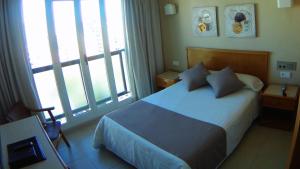 a bedroom with a bed and a large window at Hotel Albatros in Gandía
