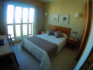 a bedroom with a bed and a large window at Hotel Albatros in Gandía