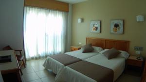 a hotel room with a large bed and a window at Hotel Albatros in Gandía