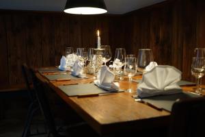 un tavolo in legno con bicchieri da vino e una candela sopra di Mara Restaurant & Hotel a Diessen am Ammersee