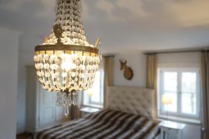 a chandelier in a room with a bed at Mara Restaurant & Hotel in Dießen am Ammersee