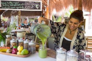 a woman pouring a green drink into a blender at The Beach Tulum Hotel in Tulum