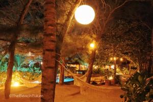 a hammock in the middle of a park at night at The Beach Tulum Hotel in Tulum