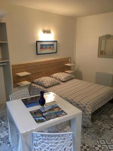 a hotel room with a bed and a table in a room at A l'Ancre Bleue in Le Tréport