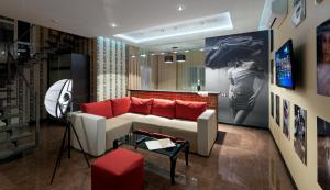 a living room with a white couch and red pillows at De Gaulle Boutique Hotel in Kharkiv