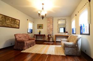 uma sala de estar com duas cadeiras e um lustre em Casa de Hospedagem Dlourdes em Ouro Preto
