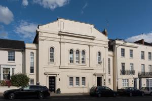 un edificio blanco con coches estacionados frente a él en 19 Chapel Court, en Leamington Spa