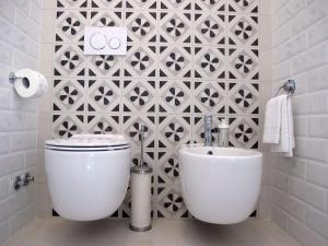 a bathroom with a toilet and a tile wall at Il Capitano in Lerici