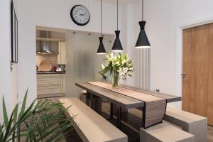 a dining room with a table and a clock on the wall at 19 Chapel Court in Leamington Spa