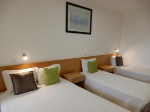 科英布拉的住宿－Guesthouse Coimbra City，酒店客房设有两张床,墙上挂着一张照片。