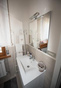 a white bathroom with a sink and a mirror at A casa di Paola in Recanati