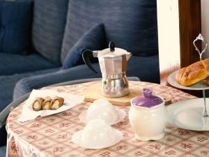 un tavolo con caffettiera e pasticcini di Appartamento Taranto a Taranto