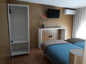 a bedroom with a bed and a television at Next to the Airport in Moreira