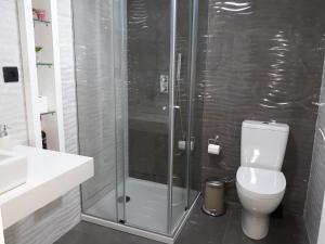 a bathroom with a toilet and a glass shower at Next to the Airport in Moreira