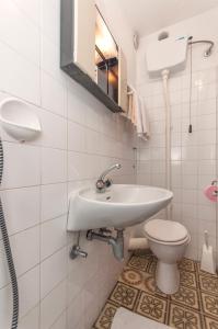 a white bathroom with a sink and a toilet at Guest house Mediteran Relax in Makarska +61 photos