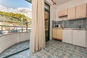 a kitchen with a balcony with a view of a mountain at Guest house Mediteran Relax in Makarska