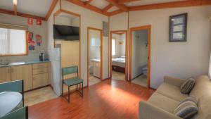 a living room with a couch and a kitchen at Dubbo Midstate Motor Park in Dubbo