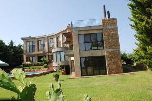 a large house with a lawn in front of it at Castle on the edge of the sea in Nea Potidaea