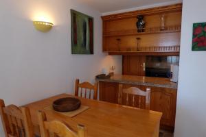 cocina y comedor con mesa de madera en Chalet Lobo, en Porís de Abona