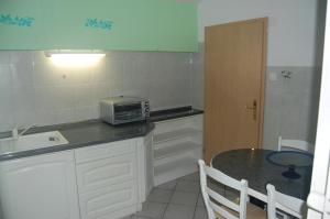 a small kitchen with a table and a microwave at Bellavista Pirano in Piran
