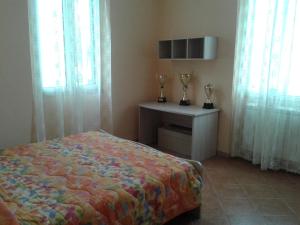Un dormitorio con una cama y una mesa con trofeos. en Casa Serena, en Messina