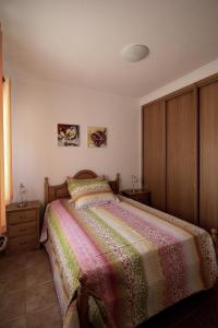 a bedroom with a bed with a colorful blanket at Monte Belo Romão in Olhão +22 photos