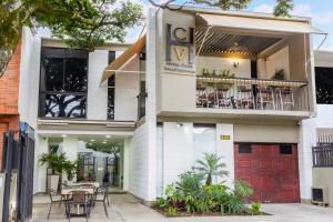 a white building with tables and chairs on the balcony at Hotel Casa Vallecaucana in Cali