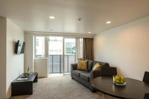 a living room with a couch and a table at Quest Ponsonby Serviced Apartments in Auckland