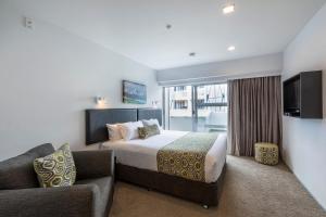 pokój hotelowy z łóżkiem i kanapą w obiekcie Quest Ponsonby Serviced Apartments w Auckland