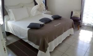 Un dormitorio con una cama blanca con almohadas. en Beauvalette en Sainte-Anne