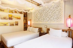 Postel nebo postele na pokoji v ubytování Hoi An Pho Library Hotel