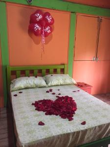 un lit avec un bouquet de roses rouges sur le lit dans l'établissement Cabañas Ecoturisticas Y Club Gaira Tayrona, à Santa Marta