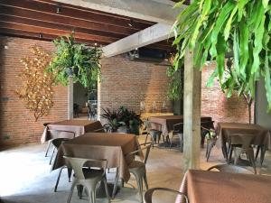 a restaurant with tables and chairs and a brick wall at Inchantreedoopool in Kanchanaburi City