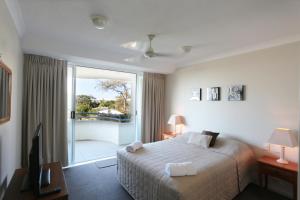 sypialnia z łóżkiem i przesuwnymi szklanymi drzwiami w obiekcie Visit the Cote D'Azur in Sunshine Beach w mieście Sunshine Beach