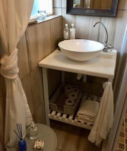La salle de bains est pourvue d'un lavabo et d'un comptoir avec des serviettes. dans l'établissement Wavey Beach Room, à Melkbosstrand
