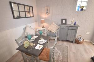 a living room with a table and a dining room at Wavey Beach Room in Melkbosstrand