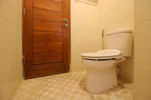 ジョグジャカルタにあるRedDoorz Plus @ Taman Siswa 2のバスルーム(トイレ付)、木製のドアが備わります。 +20枚の写真