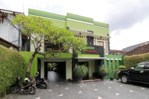 a green building with motorcycles parked in front of it at RedDoorz Plus @ Taman Siswa 2 in Yogyakarta