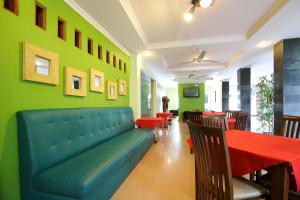 a restaurant with a couch and a table and chairs at RedDoorz Plus @ Taman Siswa 2 in Yogyakarta