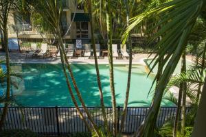 ゴールドコーストにあるBila Vista Kirra Beachside Apartmentsのホテルの前にヤシの木が茂るプール