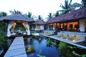 a villa with a swimming pool and a resort at Niraamaya Wellness Retreats, Surya Samudra, Kovalam in Kovalam