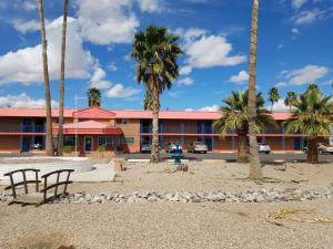 EloyにあるAmericas Best Value Inn-Eloy Casa Grandeの建物の前にヤシの木があるホテル