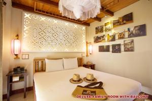 Postel nebo postele na pokoji v ubytování Hoi An Pho Library Hotel