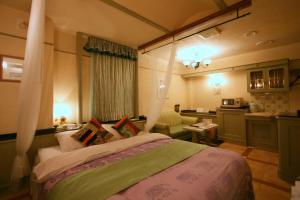 a bedroom with a large bed and a kitchen at Provance no machini Sakuranomiya (Adult only) in Osaka
