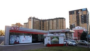 ヴォロネジにあるАпартаменты на Московском проспектеの高層ビルのある都市のガソリンスタンド