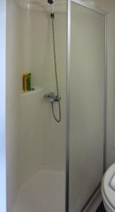 a shower with a glass door in a bathroom at Hôtel Noctuel Blois Sud in Saint-Gervais-la-Forêt