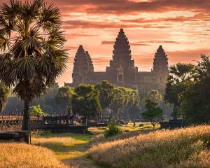 vistas a un templo al atardecer con una palmera en Summer Bliss Boutique, en Siem Reap