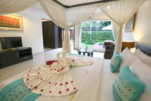 a bedroom with two gowns on a bed at The Yubi Boutique Villas Seminyak - CHSE Certified in Seminyak