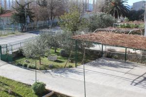 een tuin met bomen en een hek bij Apartments Vulić in Omiš