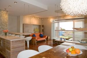 uma cozinha e sala de estar com mesa e cadeiras em Atlantik Sicht Apartment em Swakopmund